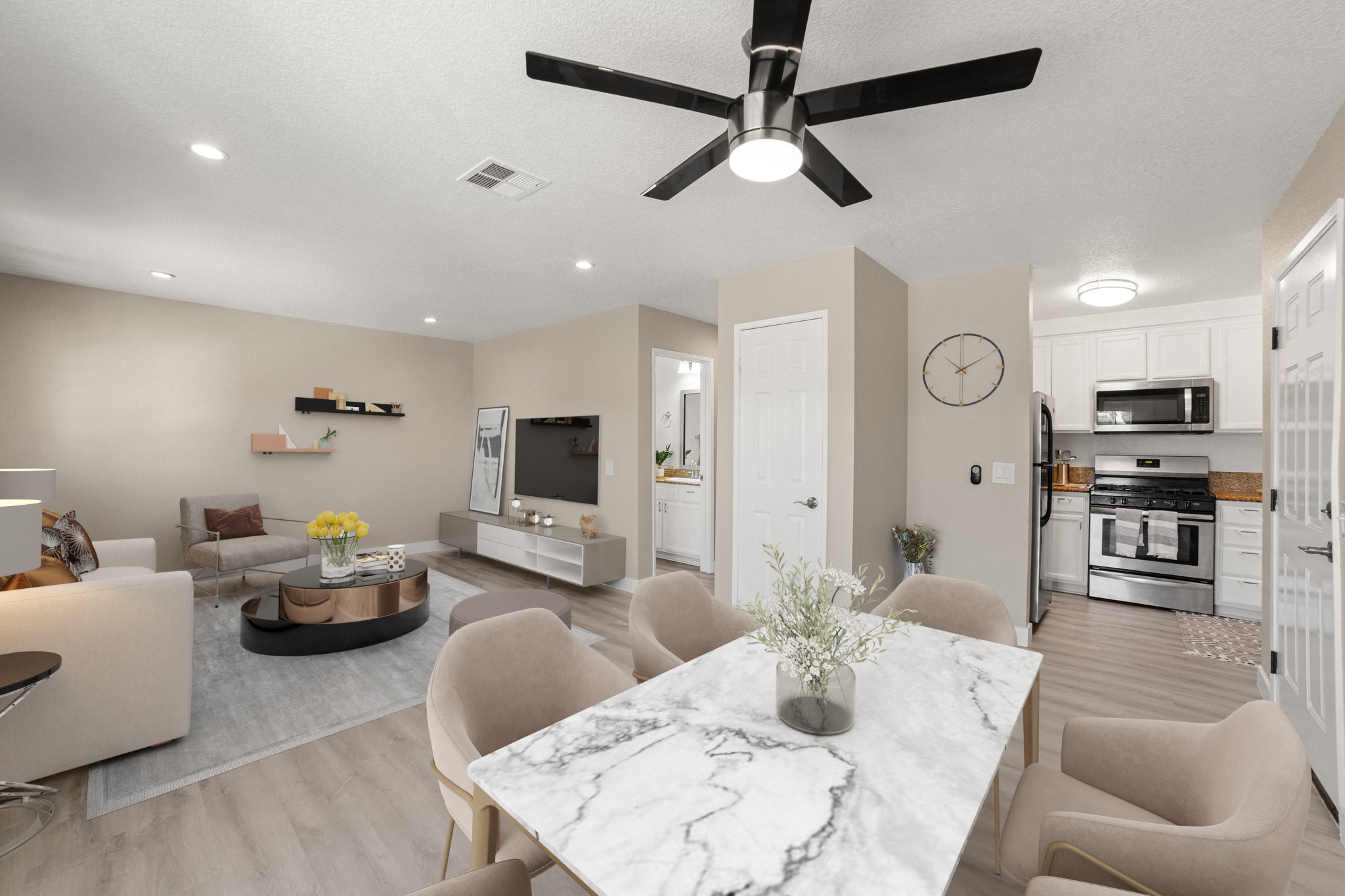 A modern living room with a marble table and a ceiling fan.